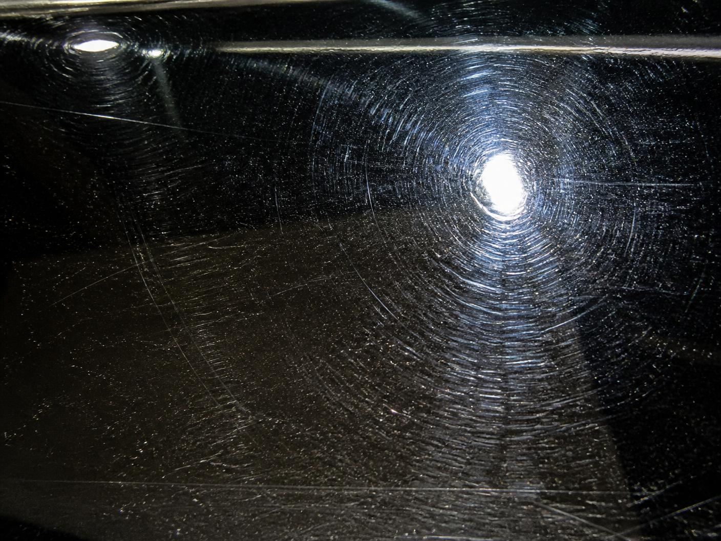 Pintura negra con micro rayones y marcas de lavado antes del polichado profesional