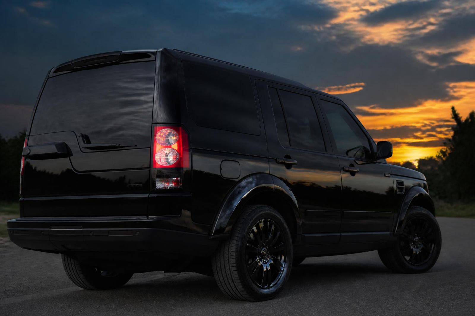SUV negra con bumper, molduras y accesorios plásticos completamente restaurados por Carsmot Bogotá al atardecer